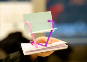 Der 10 Minuten Stuhl, der aus Büromaterialien, hier Strohhalme und Pappe, gebaut wird, um Design zu vermitteln.