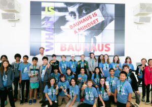 Eine Gruppe Schüler:innen vor einem Plakat auf dem steht: Bauhaus is a mindset.